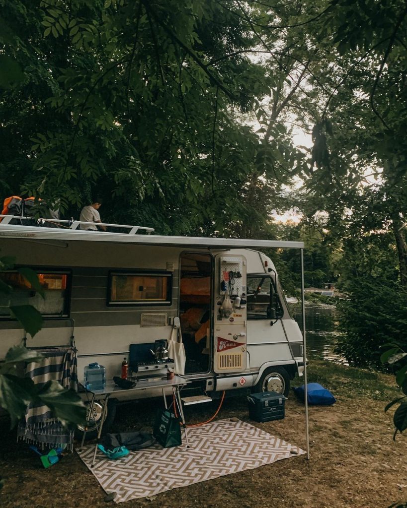 Couple sitting outside their insured motorhome
